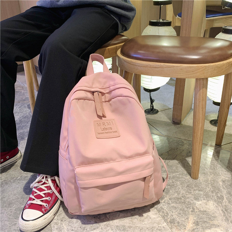 Durable and spacious solid nylon backpack for both men and women, ideal for school or travel, available in various colors